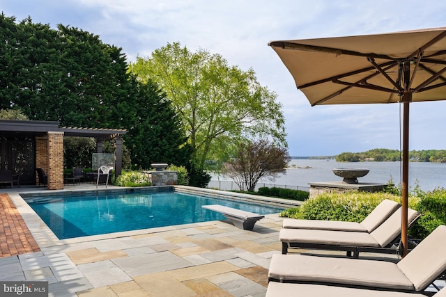 view of swimming pool featuring a diving board, a patio area, a fenced in pool, fence, and a water view