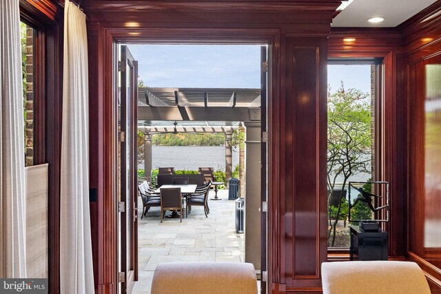 doorway featuring wood walls, a water view, and stone finish floor