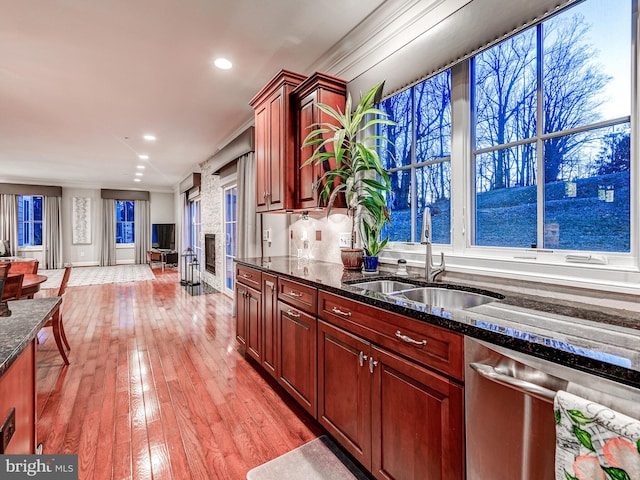 6 Paladia Way, Pikesville, MD 21208 - kitchen with a sink, a fireplace, dishwasher, light wood-type flooring, and dark stone counters