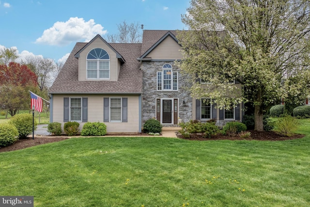 view of front of home with stone siding, a shingled roof, and a front yard