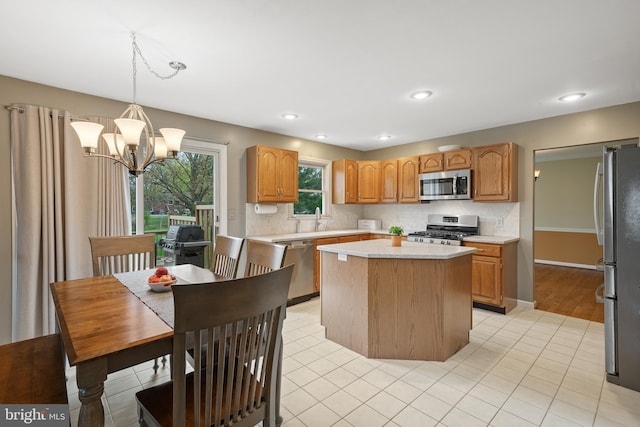 kitchen with a chandelier, decorative backsplash, a center island, and stainless steel appliances