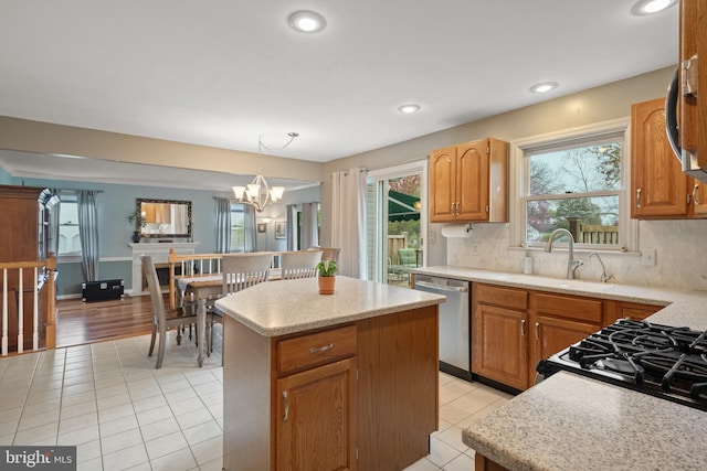 kitchen featuring a center island, an inviting chandelier, appliances with stainless steel finishes, and light tile patterned floors