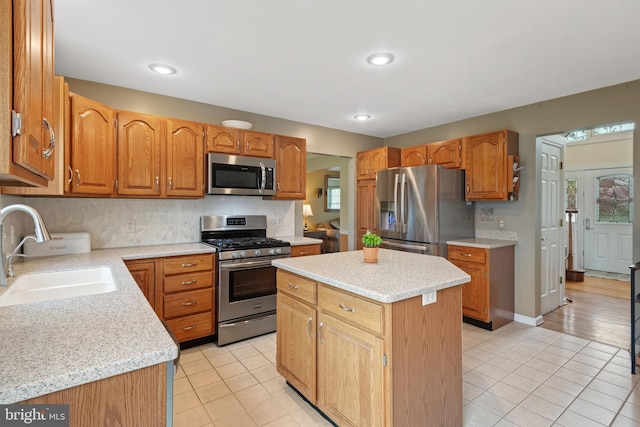 kitchen with light tile patterned floors, a center island, a sink, and appliances with stainless steel finishes