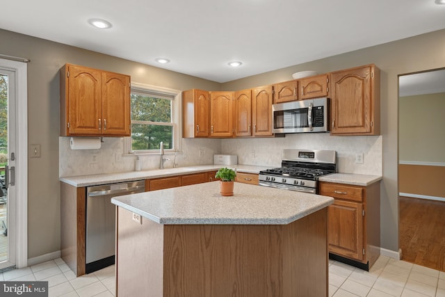 kitchen featuring baseboards, tasteful backsplash, stainless steel appliances, and light countertops