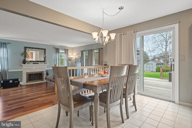 dining area with a chandelier, a fireplace, baseboards, and light tile patterned floors