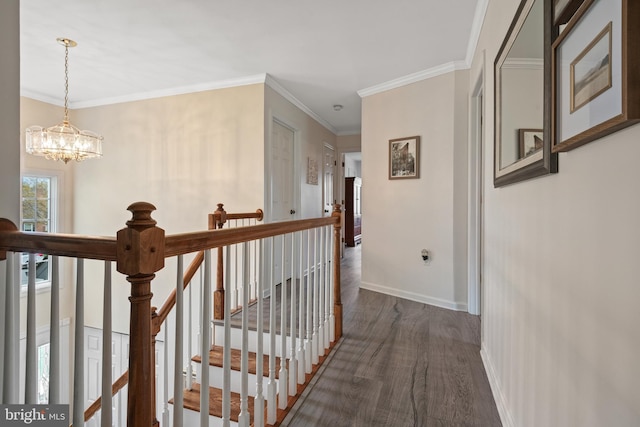 corridor featuring dark wood finished floors, an upstairs landing, crown molding, baseboards, and a notable chandelier