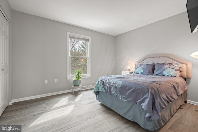 bedroom featuring baseboards, wood finished floors, and visible vents