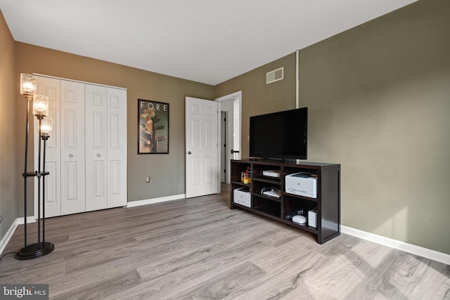 living room with baseboards, wood finished floors, and visible vents