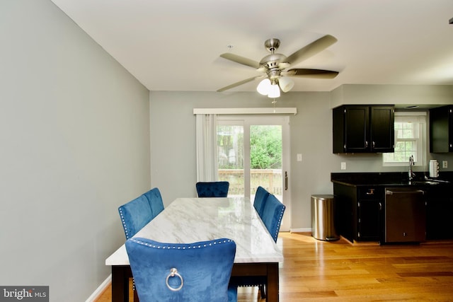 dining room featuring plenty of natural light, a ceiling fan, baseboards, and light wood-type flooring