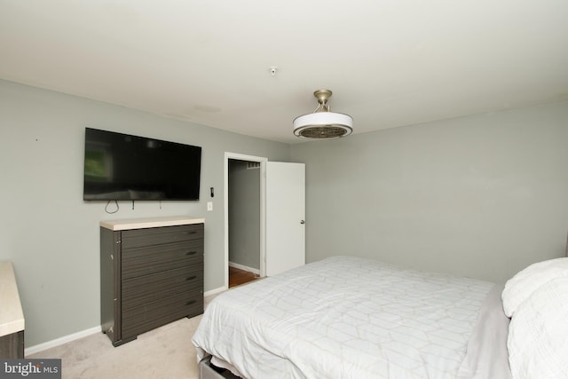 bedroom with baseboards and light carpet