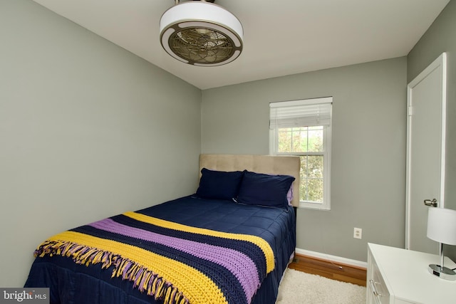 bedroom with baseboards and wood finished floors