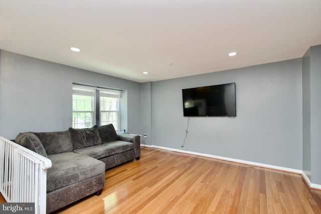 living area with recessed lighting, baseboards, and light wood-type flooring