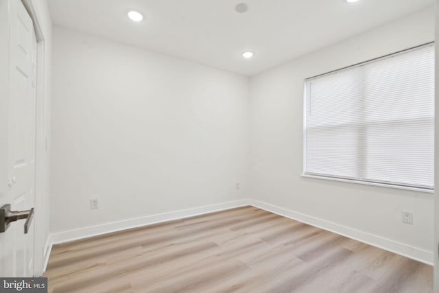 spare room with baseboards, light wood-type flooring, and recessed lighting