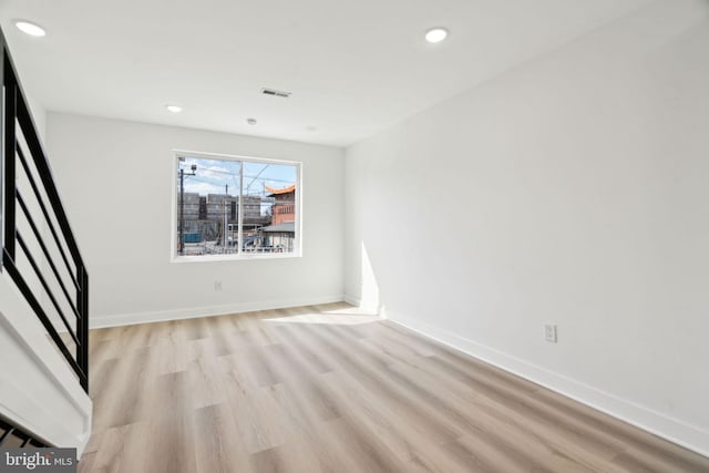 empty room featuring baseboards, visible vents, light wood-style floors, and recessed lighting