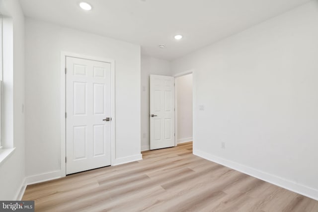 unfurnished bedroom featuring baseboards, light wood-type flooring, and recessed lighting