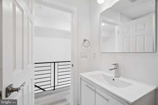 bathroom with wood finished floors and vanity