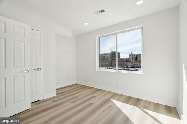 unfurnished bedroom with baseboards, light wood-style flooring, visible vents, and recessed lighting