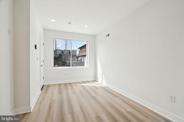 spare room featuring baseboards, visible vents, light wood-style flooring, and recessed lighting