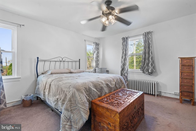 carpeted bedroom with multiple windows, radiator heating unit, and a ceiling fan