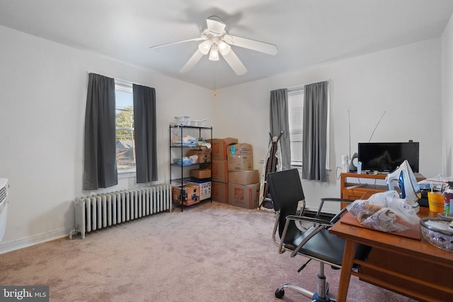 carpeted office featuring radiator heating unit and ceiling fan