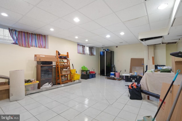below grade area with tile patterned flooring, recessed lighting, and a drop ceiling
