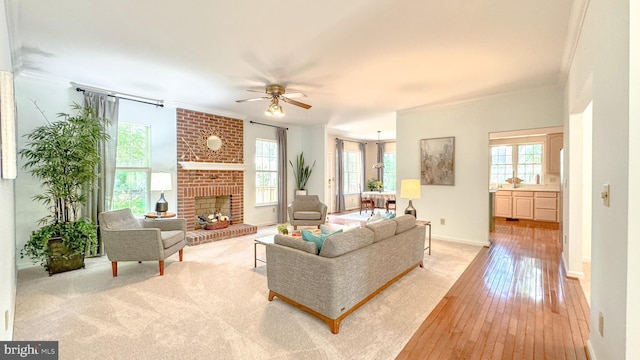 1009 Cadmus Dr, Fredericksburg, VA 22401 - living area featuring ceiling fan, light wood finished floors, a brick fireplace, crown molding, and baseboards