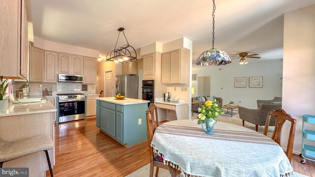 1009 Cadmus Dr, Fredericksburg, VA 22401 - kitchen with appliances with stainless steel finishes, a center island, light wood finished floors, a ceiling fan, and light countertops