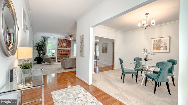 1009 Cadmus Dr, Fredericksburg, VA 22401 - dining room featuring crown molding, a chandelier, wood finished floors, baseboards, and a brick fireplace