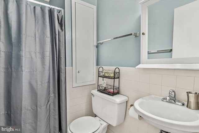 25112 Applecross Ter, Damascus, MD 20872 - full bath featuring a sink, tile walls, toilet, a shower with curtain, and a wainscoted wall