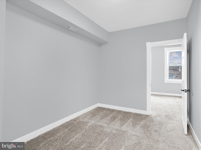 spare room with baseboards, visible vents, and carpet