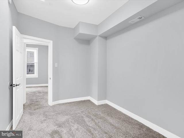 unfurnished room with baseboards, visible vents, and carpet