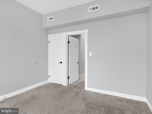 carpeted empty room with baseboards and visible vents