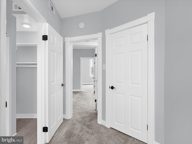 corridor with carpet, baseboards, and visible vents