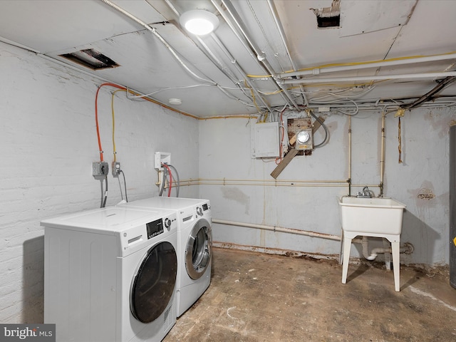 laundry area featuring electric panel, washing machine and dryer, and laundry area
