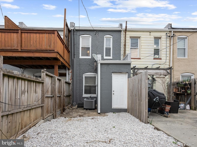 rear view of property featuring a fenced backyard, cooling unit, and brick siding