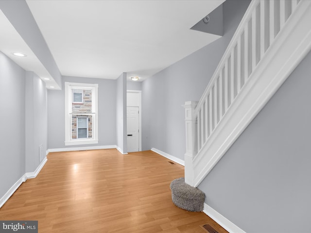 living area featuring baseboards, recessed lighting, light wood-style floors, and stairway
