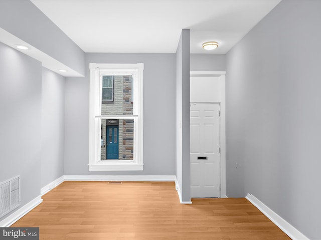 spare room featuring baseboards, visible vents, and light wood-style floors