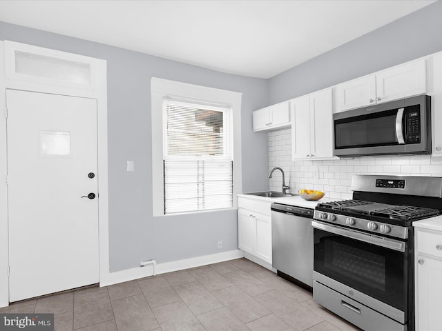 kitchen with tasteful backsplash, white cabinets, a sink, and stainless steel appliances