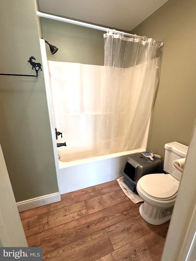 bathroom with toilet, shower / bath combo, and wood finished floors