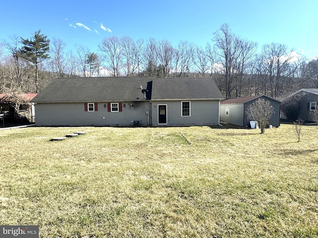 rear view of house with an outbuilding, central AC unit, a storage unit, and a yard