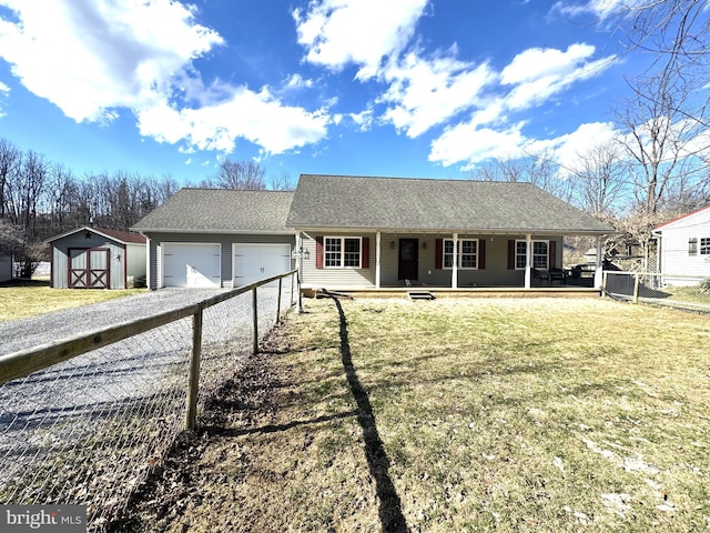 ranch-style home with fence, an attached garage, driveway, covered porch, and a shed