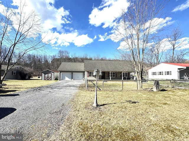 ranch-style home with gravel driveway, a front lawn, fence, and an attached garage