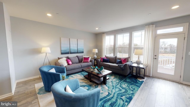 living area with baseboards, wood finished floors, and recessed lighting