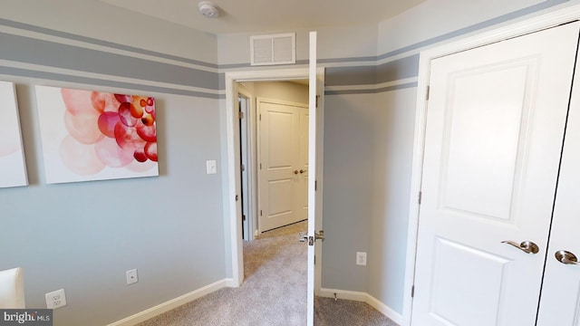 unfurnished bedroom featuring baseboards, carpet flooring, and visible vents