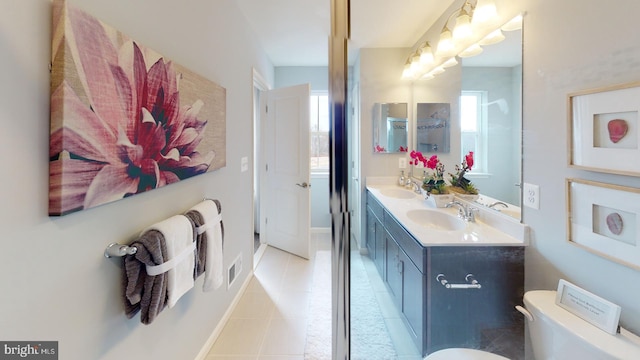 bathroom featuring double vanity, toilet, tile patterned flooring, and a sink