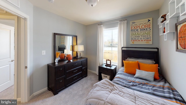 bedroom with light carpet and baseboards