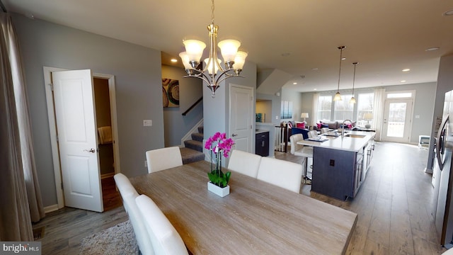 dining area featuring stairs, a notable chandelier, light wood-style flooring, and recessed lighting