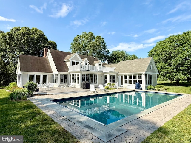 6549 Locust Grove Rd, Easton, MD 21601 - rear view of property with a balcony, an outdoor pool, a yard, a patio area, and a chimney