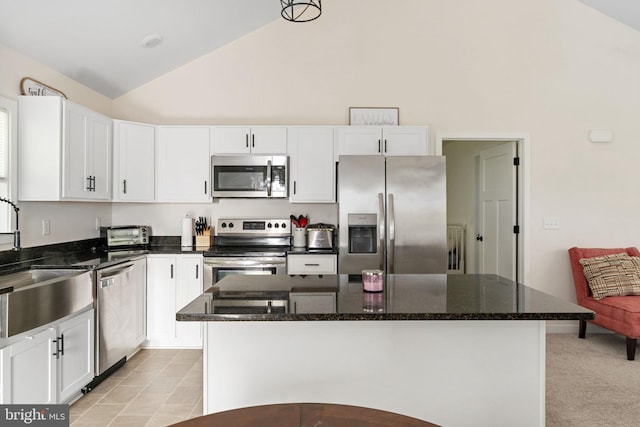 kitchen featuring a sink, appliances with stainless steel finishes, white cabinets, and high vaulted ceiling