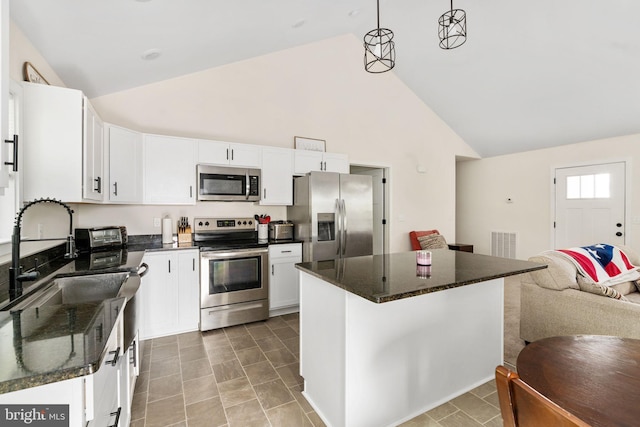 kitchen with white cabinets, stainless steel appliances, visible vents, and open floor plan
